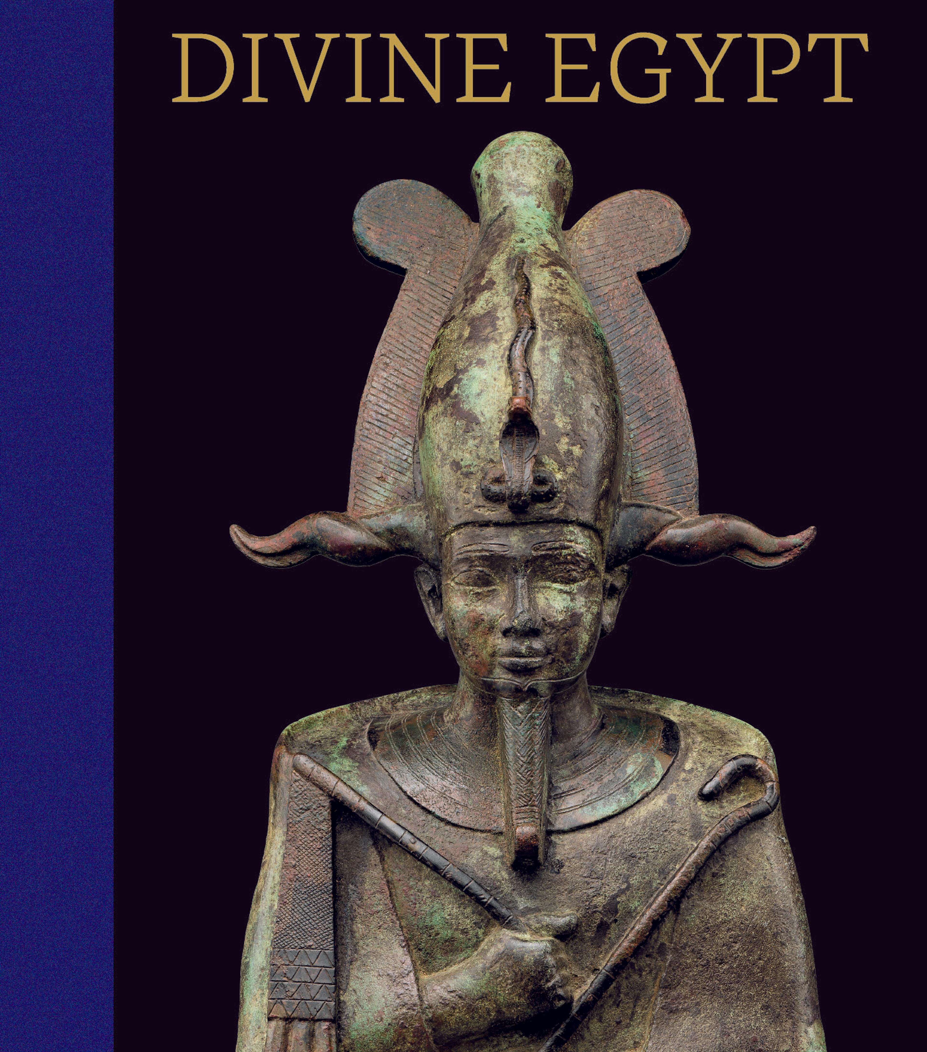 a faded bronze statue of an Egyptian god's head and torso, holding a rod, with an elaborate headdress