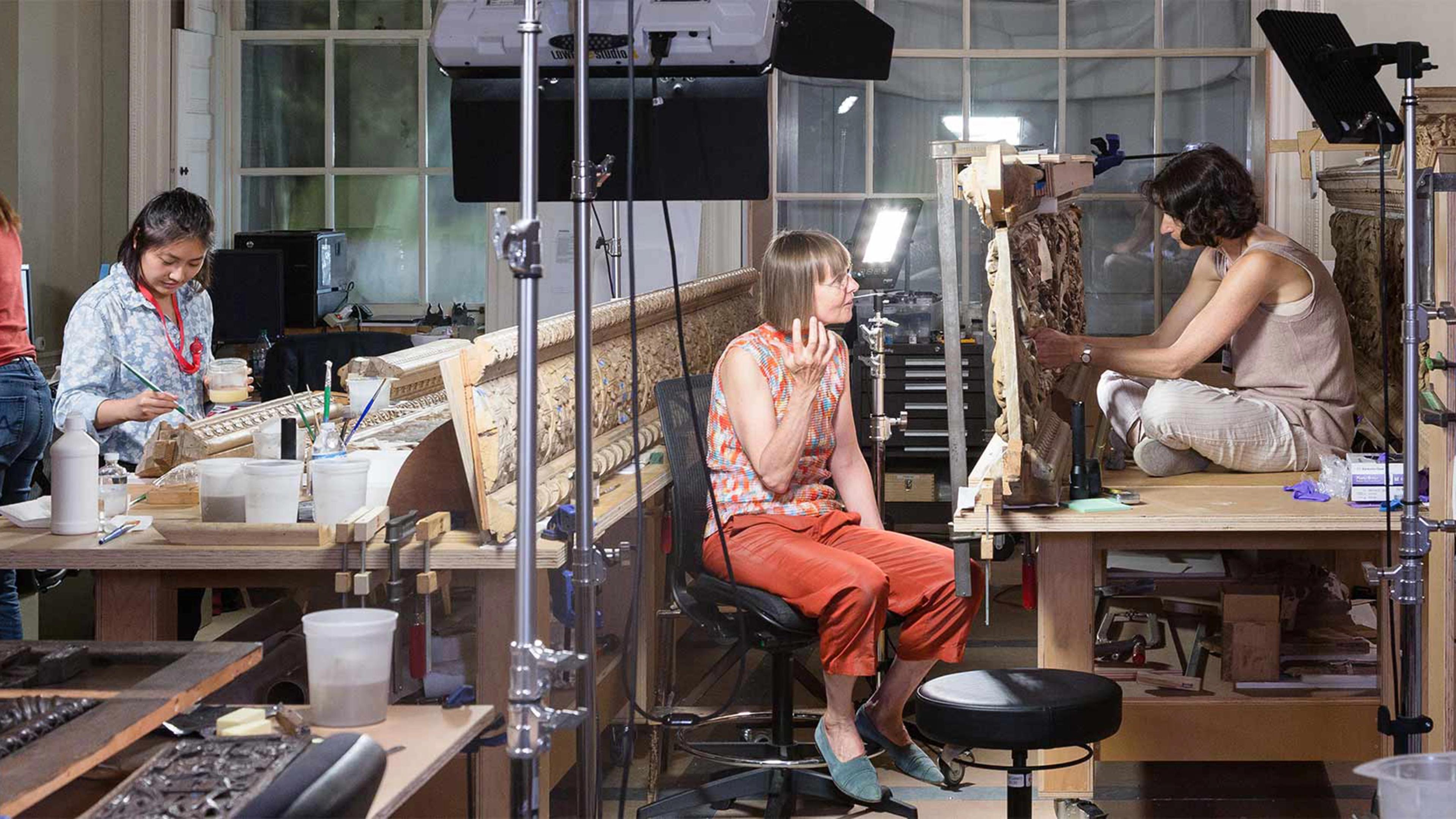 Two conservators in their lab staining wood paneling for the British Galleries